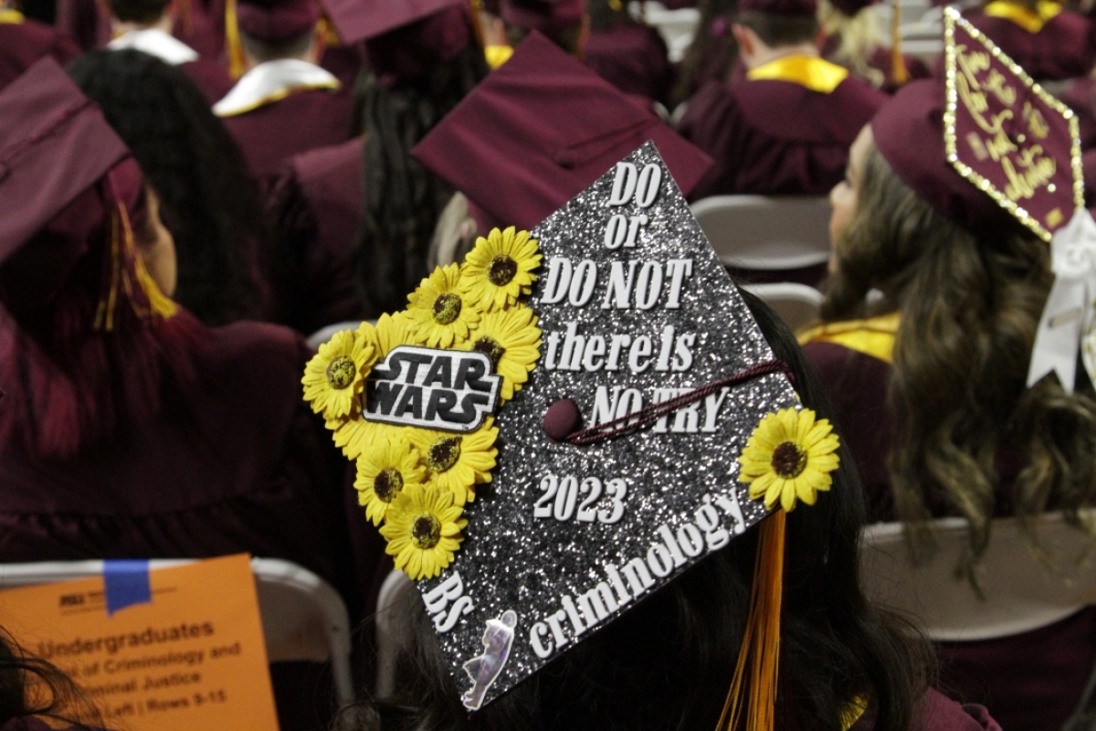 A close-up photo of a grad's cap decorated with a Star Wars theme.