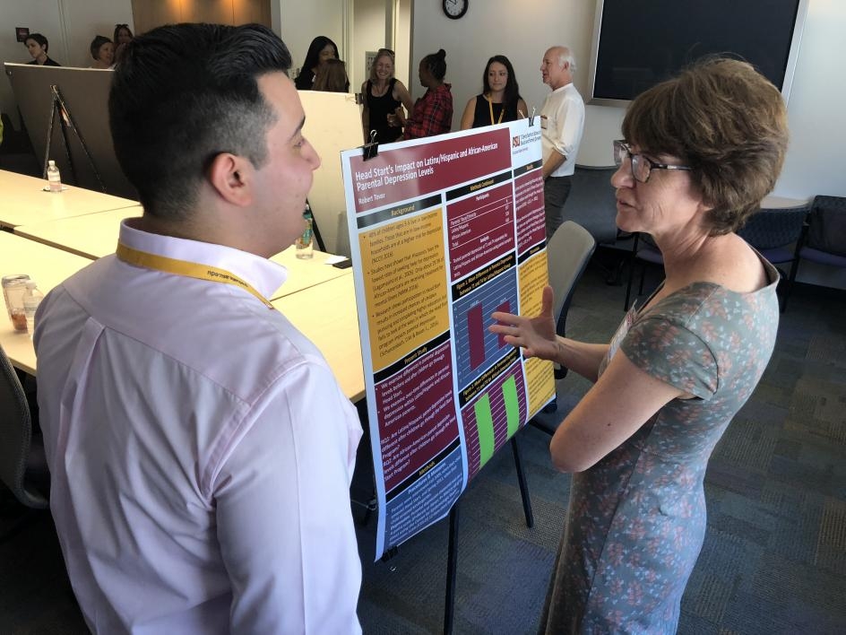 SUPER fellow presenting his research poster to a faculty member.
