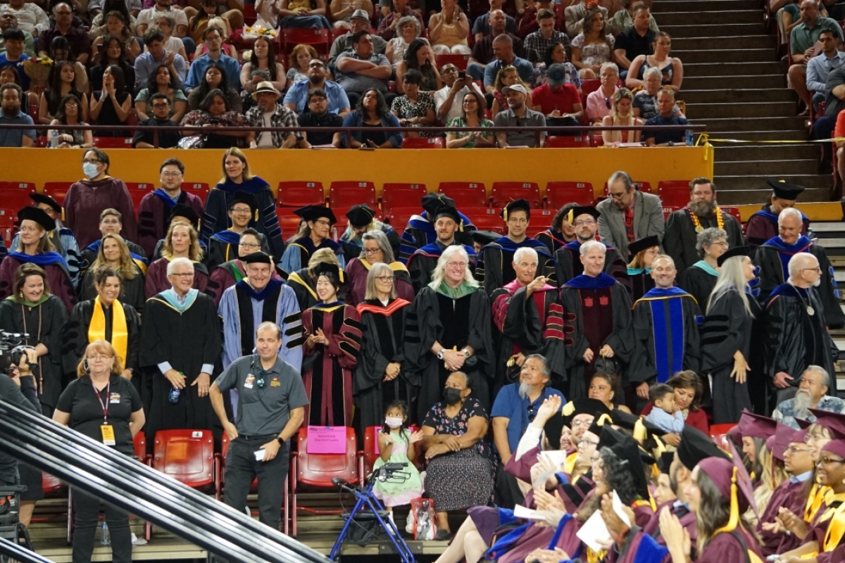 Watts College faculty members stand as they are recognized at the spring 2023 convocation