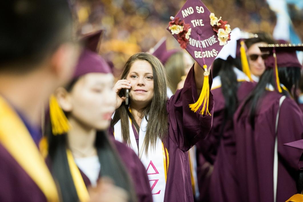 student waiving at commencement
