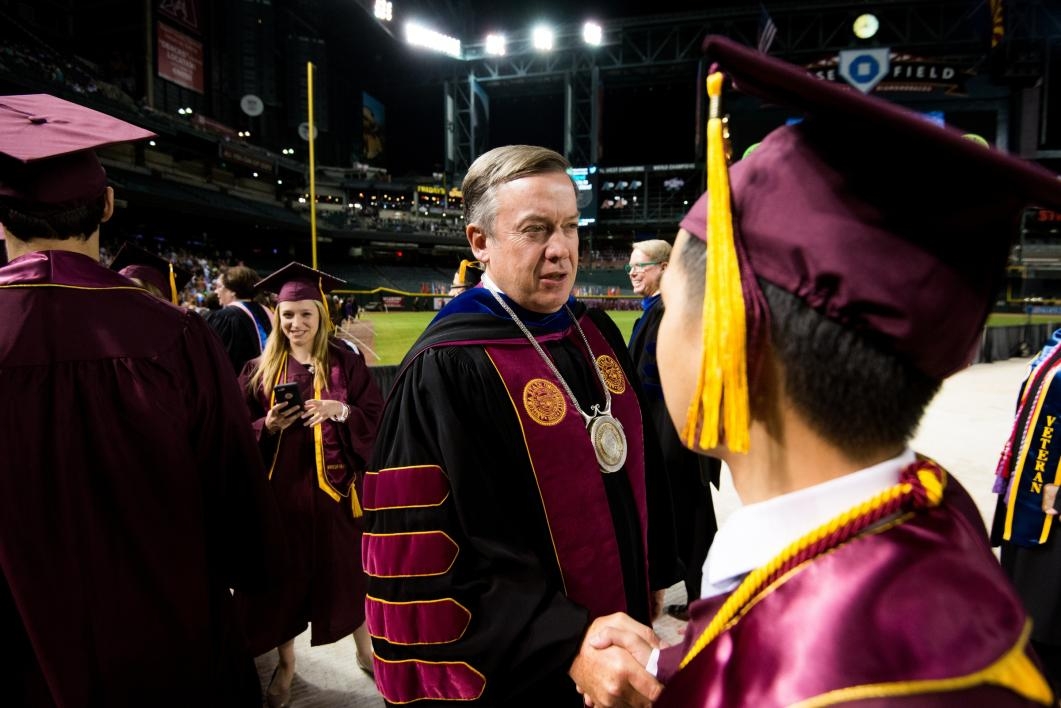 ASU President shaking hands with student