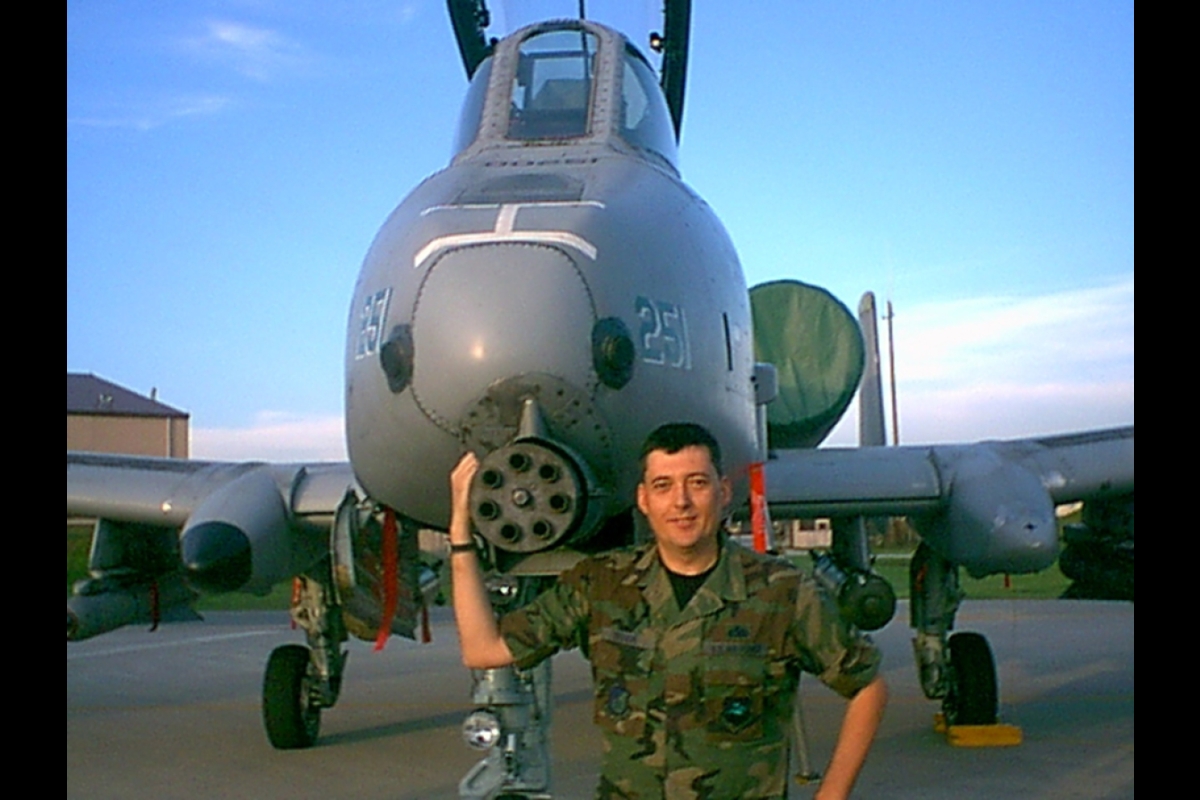 man standing in front of military plane