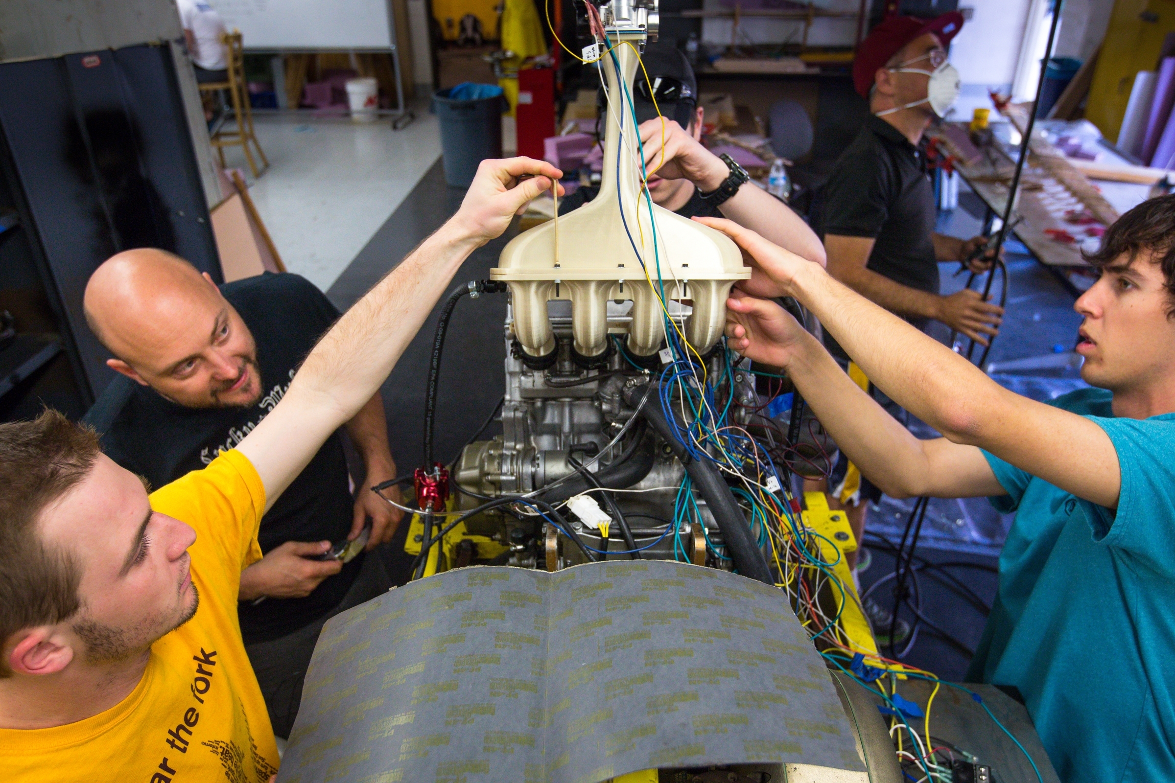 Students work on a throttle in a Formula-style race car.