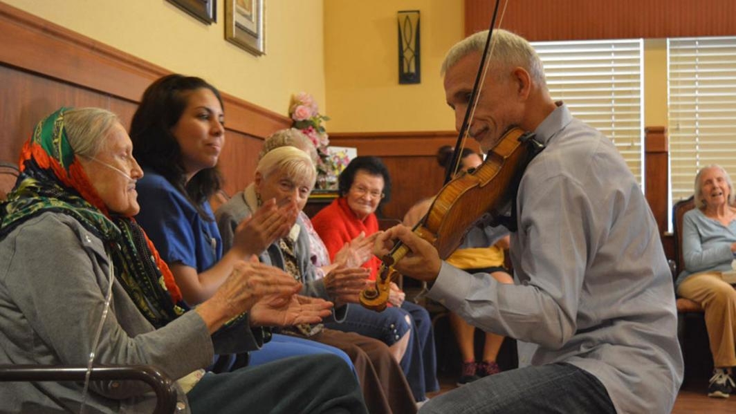 A man plays violin at a nursing home