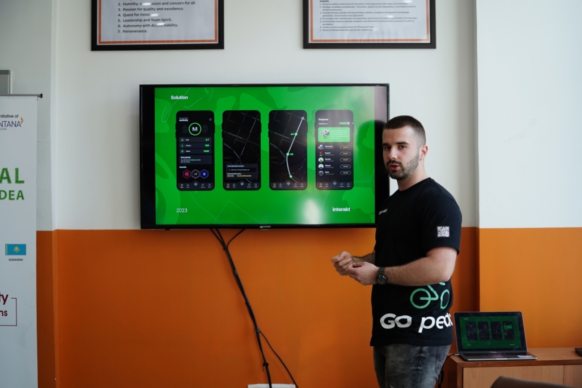Student presents startup idea in front of television screen
