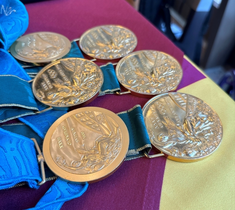 Olympic gold medals laid out on a table.