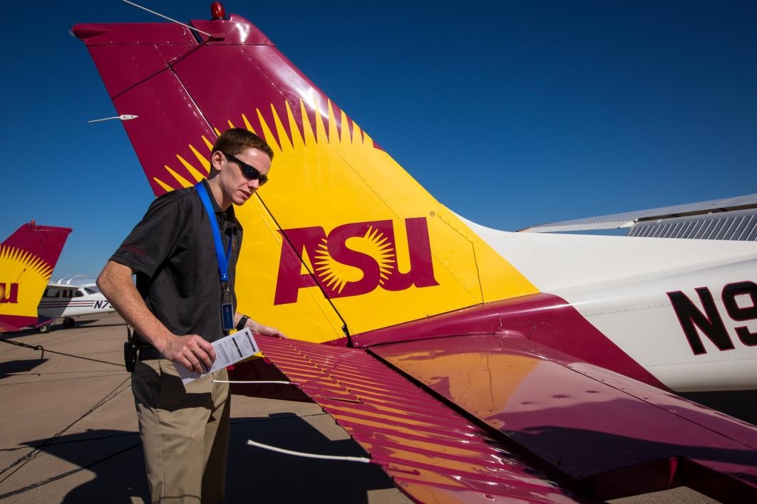 An aviation student checks the plane before takeoff.