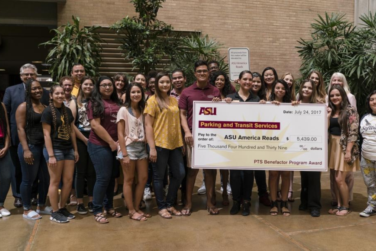 ASU America Reads student tutors, Mary Lou Fulton Teachers College deans and program directors and Parking and Transit Services directors gather around the PTS Benefactor Program presentation check. PTS donated 2016-17 Benefactor Program funds to ASU Amer
