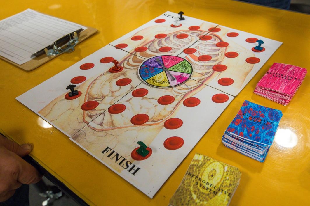 The pieces of a student-created medical board game are displayed on a table.