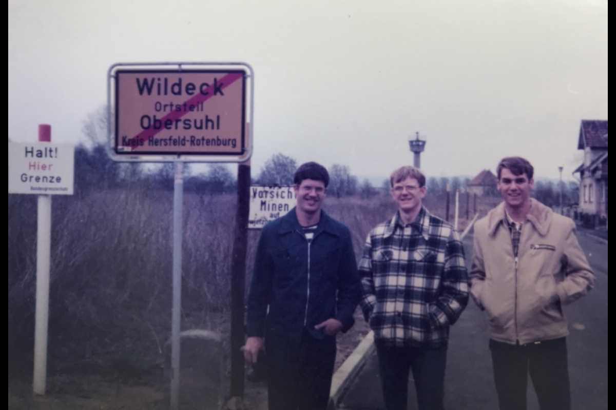 Three members of the 4NW stand in West Germany with communist East Germany behind them.