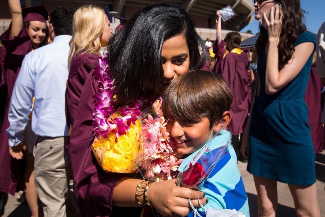 graduate hugging little boy