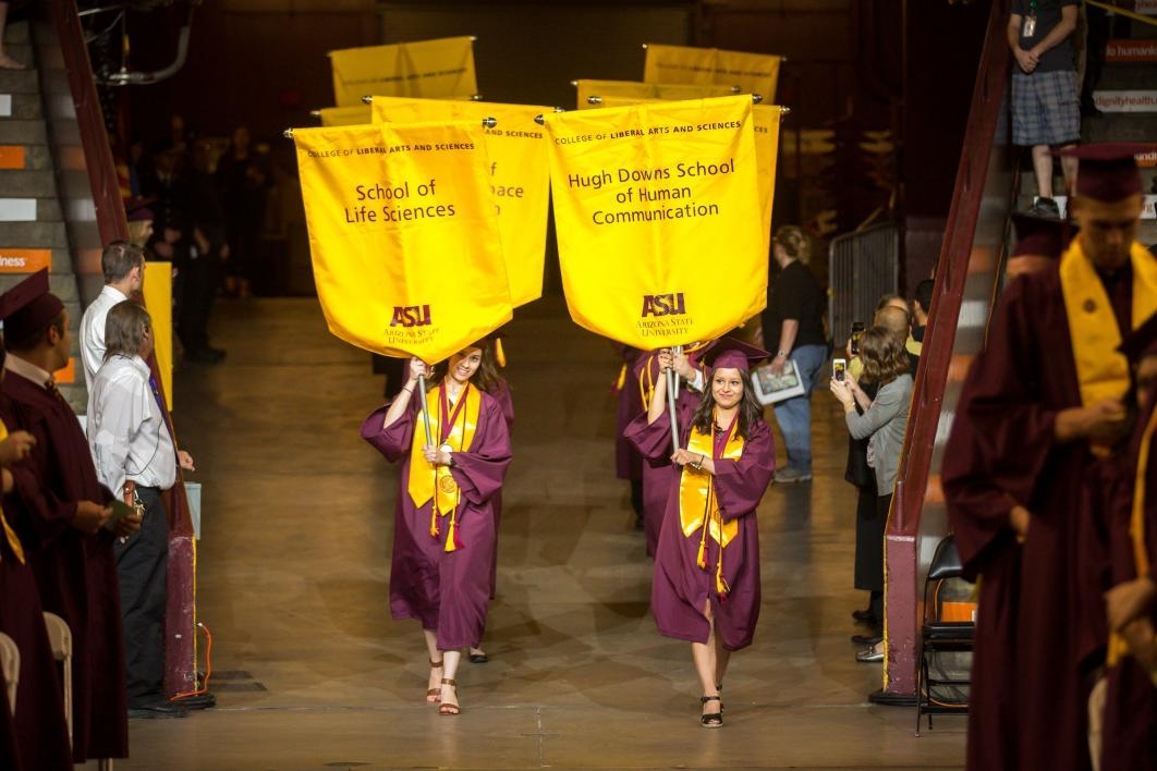 graduates carrying school gonfalons