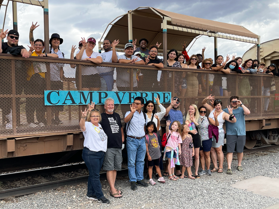 Group of students pose in front of Verde Railroad train car