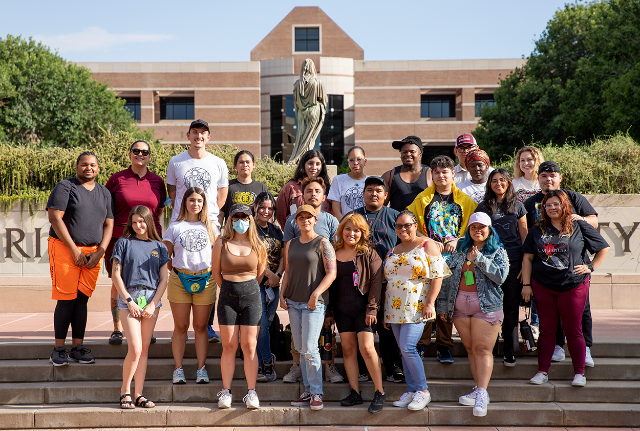 Group of students pose on steps outside of Fletcher Library at ASU's West campus.