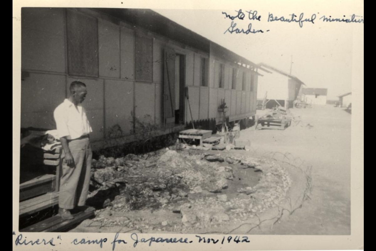 man standing outside his home next to a garden