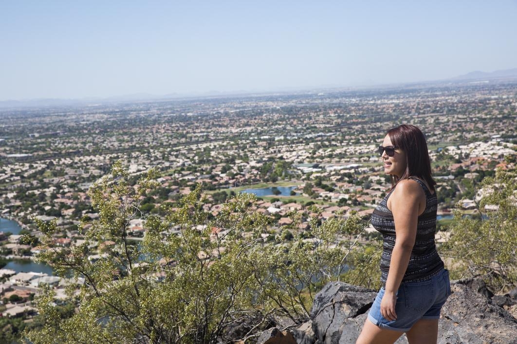 girl looking out over mountain view of city