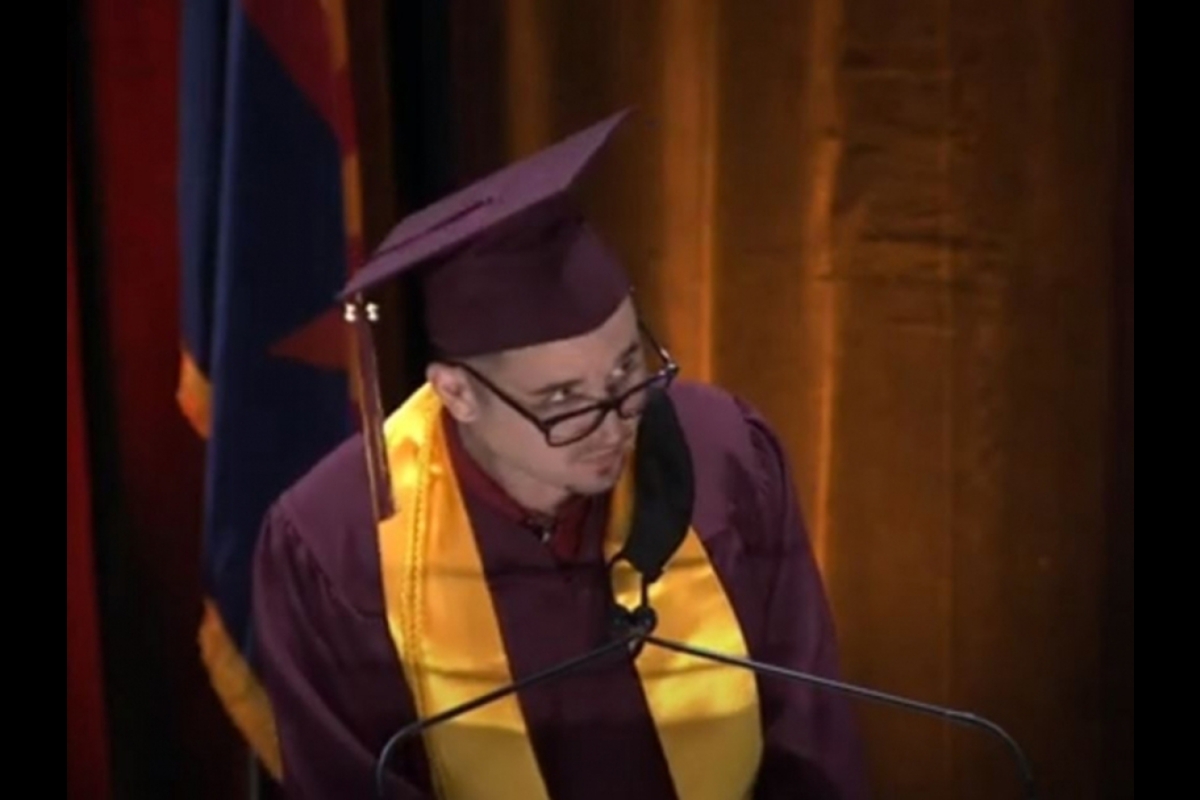 student speaking at lectern during commencement