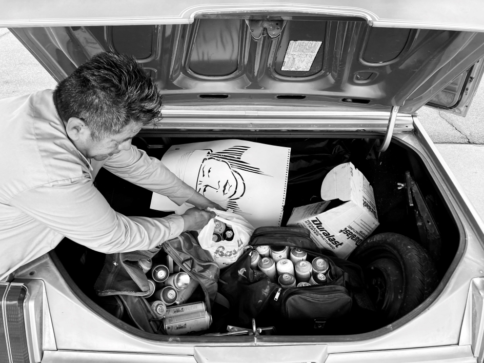 Douglas Miles pulling painting supplies from his trunk.