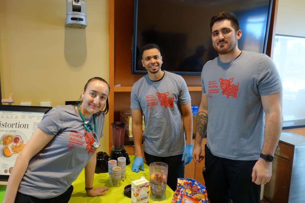 Nursing students Mihaela Dan, Jared Posey and Michael Wald prepare smoothies at the nutrition station 