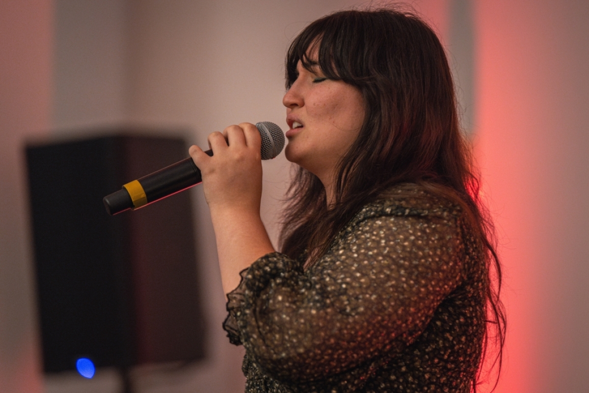 Woman singing into a microphone.