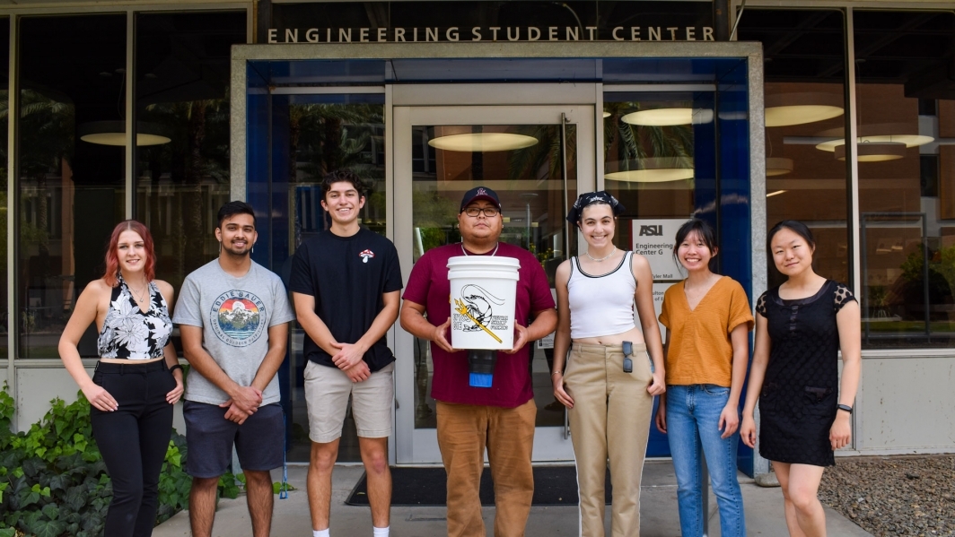 EPICS Vietnam Shrimp Farming student team holding their prototype in front of ASU's Engineering Student Center.