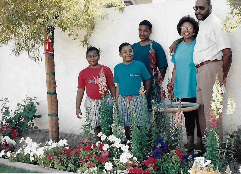 The late ASU Professor Elsie Moore and her family smiling outside in a garden.