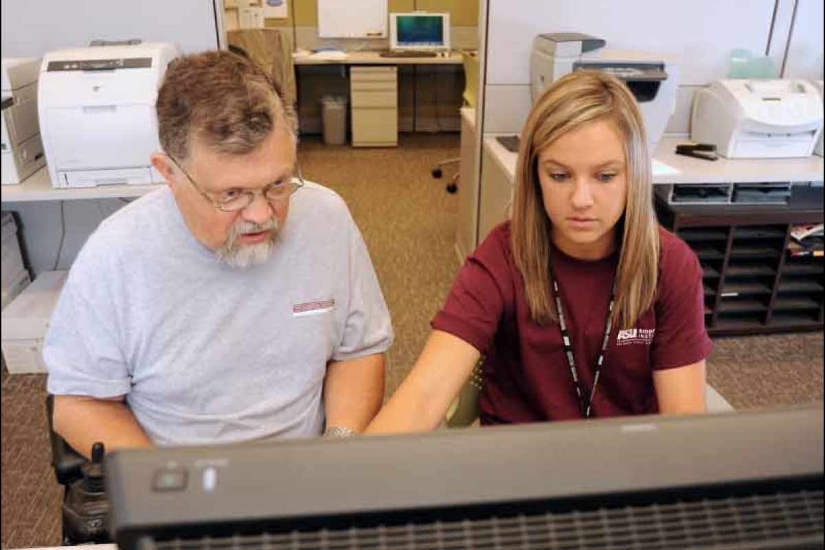 The late ASU resercher Alan Filipski and a female student intern sit together at a computer.
