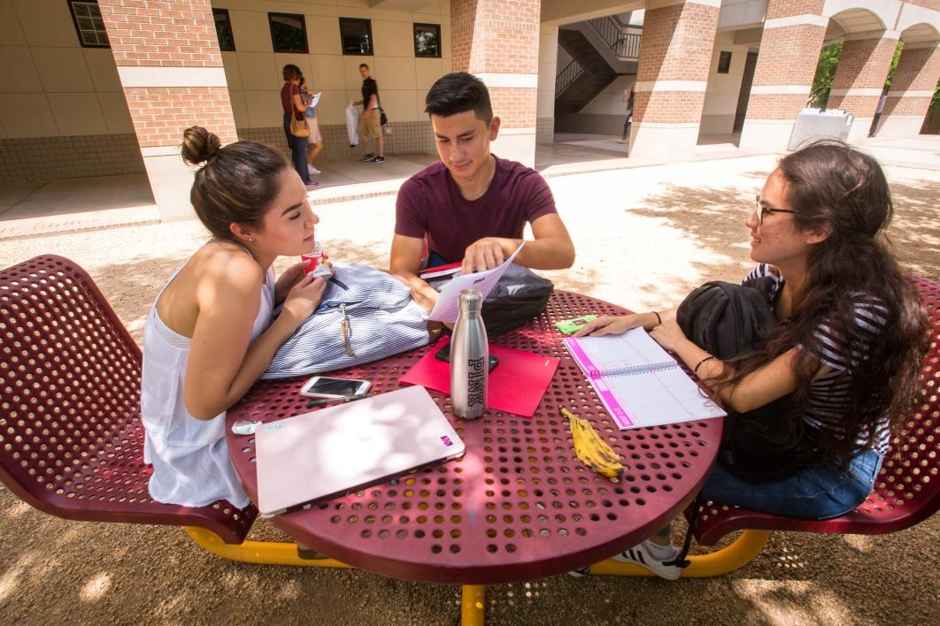 students sitting around table on campus