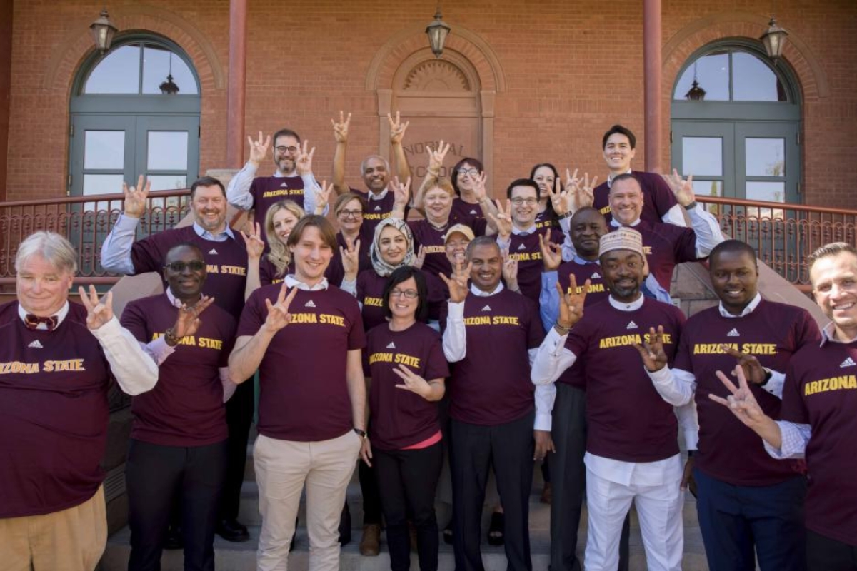 Students, faculty and administrators from Chemonics and ASU pose in front of Old Main after graduation ceremony.