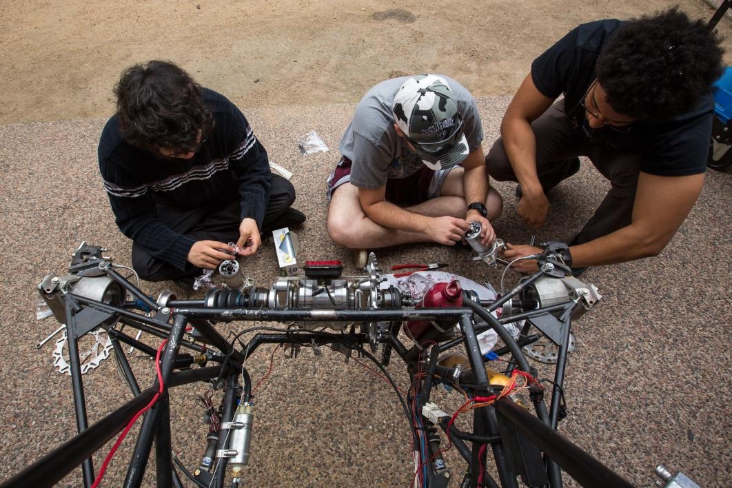 Formula SAE students work on the car's brakes.