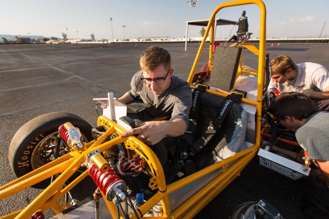 Students run diagnostics on the race car on the test track.
