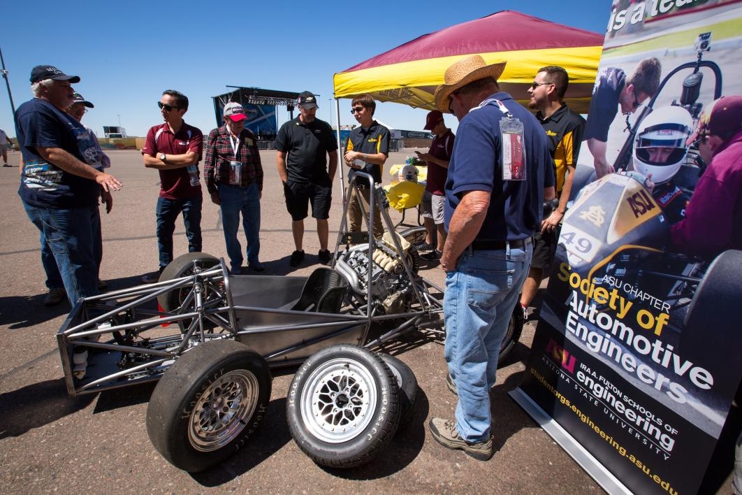 A crowd looks at the in-progress car being built by ASU students.
