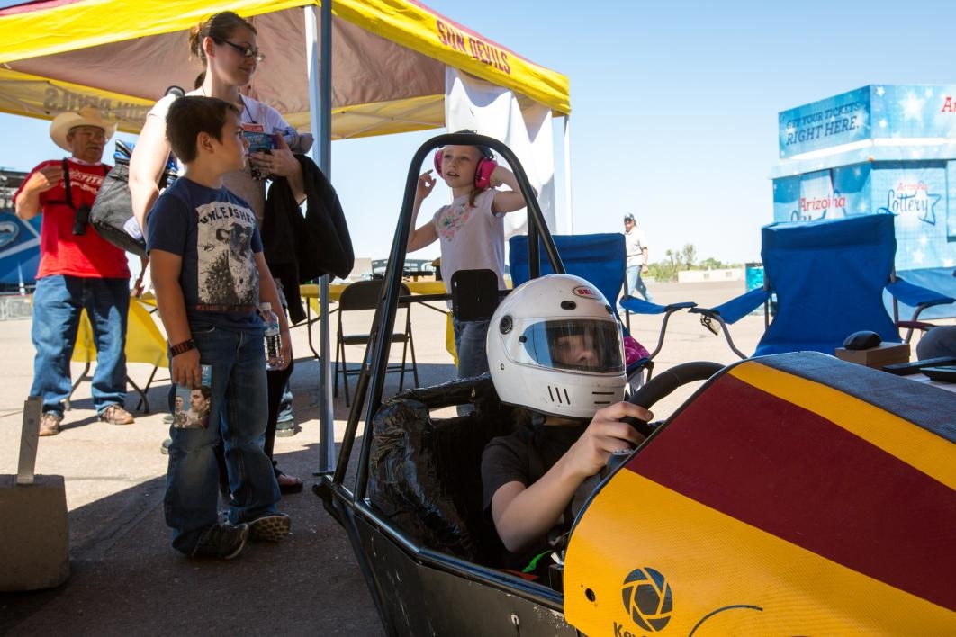 A young child plays in a race-car simulator.
