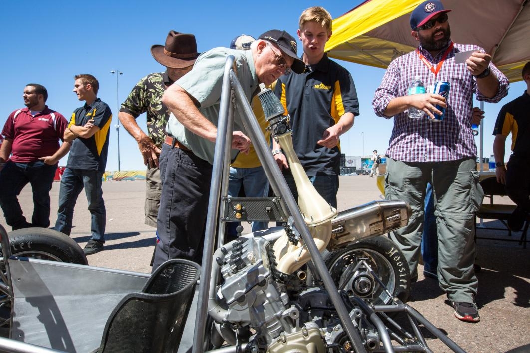 An older man checks out the in-progress race car built by ASU students.