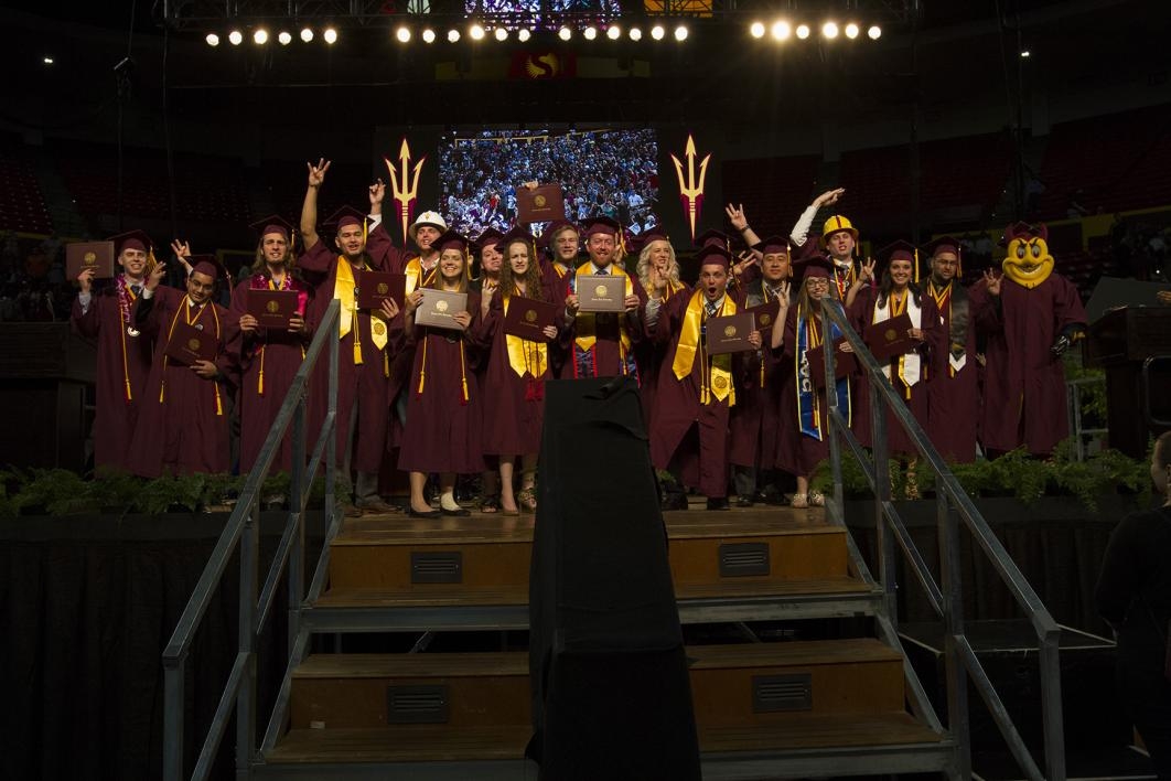 group of graduates posing at graduation