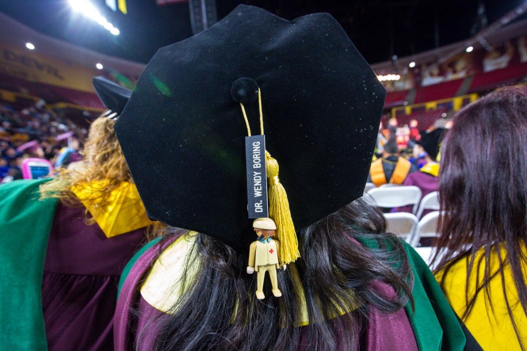 Interesting doll on someone's graduation hat.