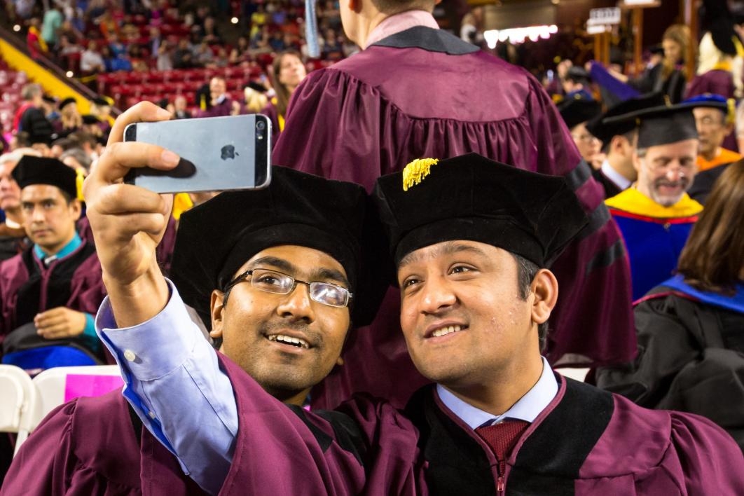 Students take selfies at ASU's Graduate Commencement