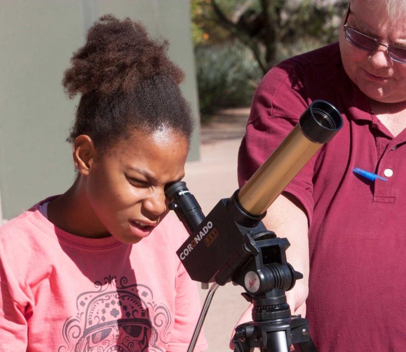 Scout looks at the sun through a telescope at ASU Polytechnic campus