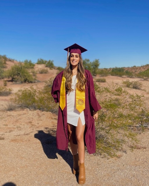 woman wearing cap and gown in desert setting