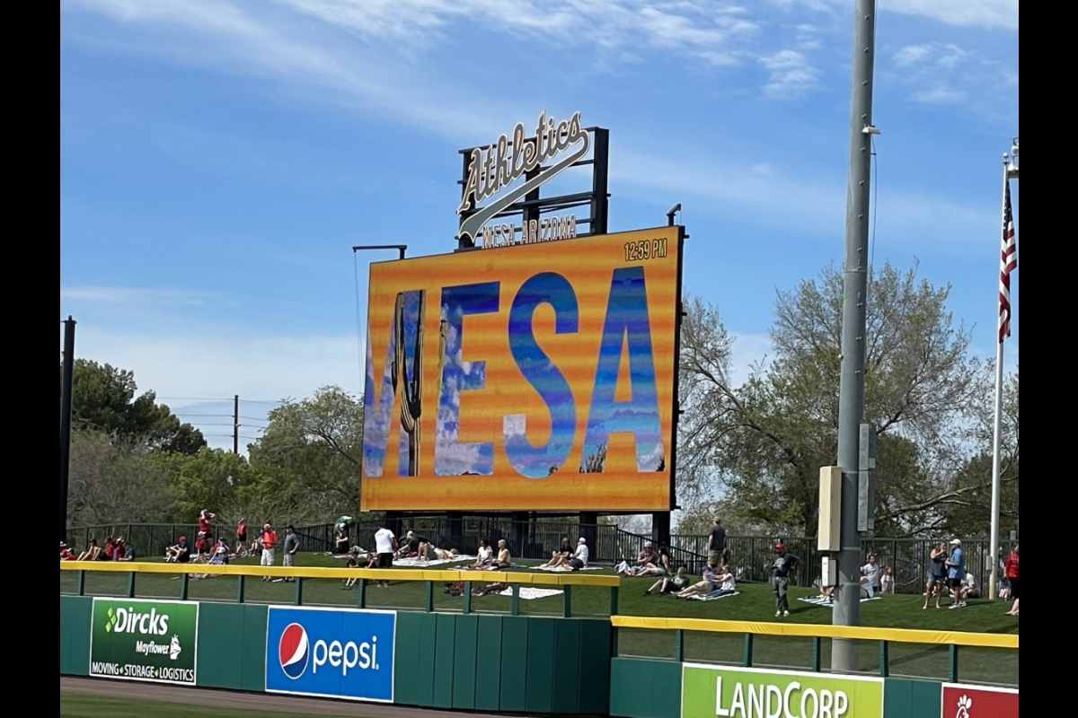 A scoreboard on a baseball field that reads "MESA."