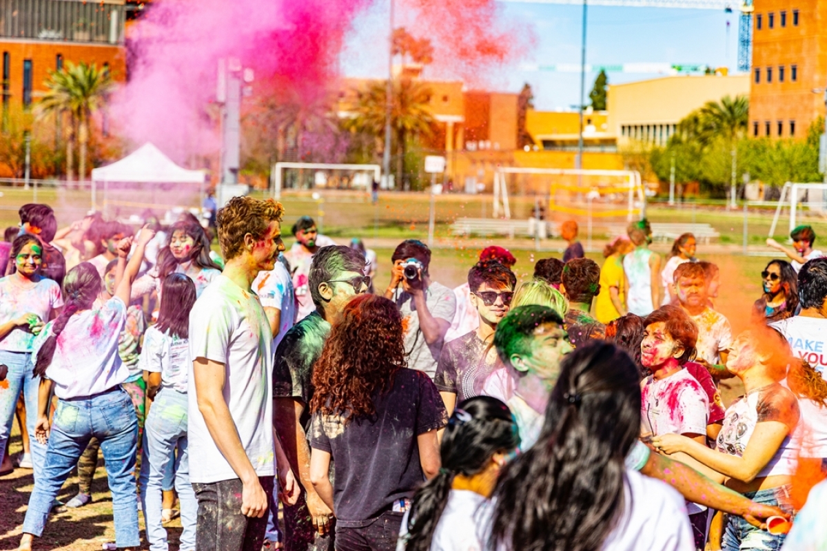 A group of students splashed with colorful powder at the Holi festival.