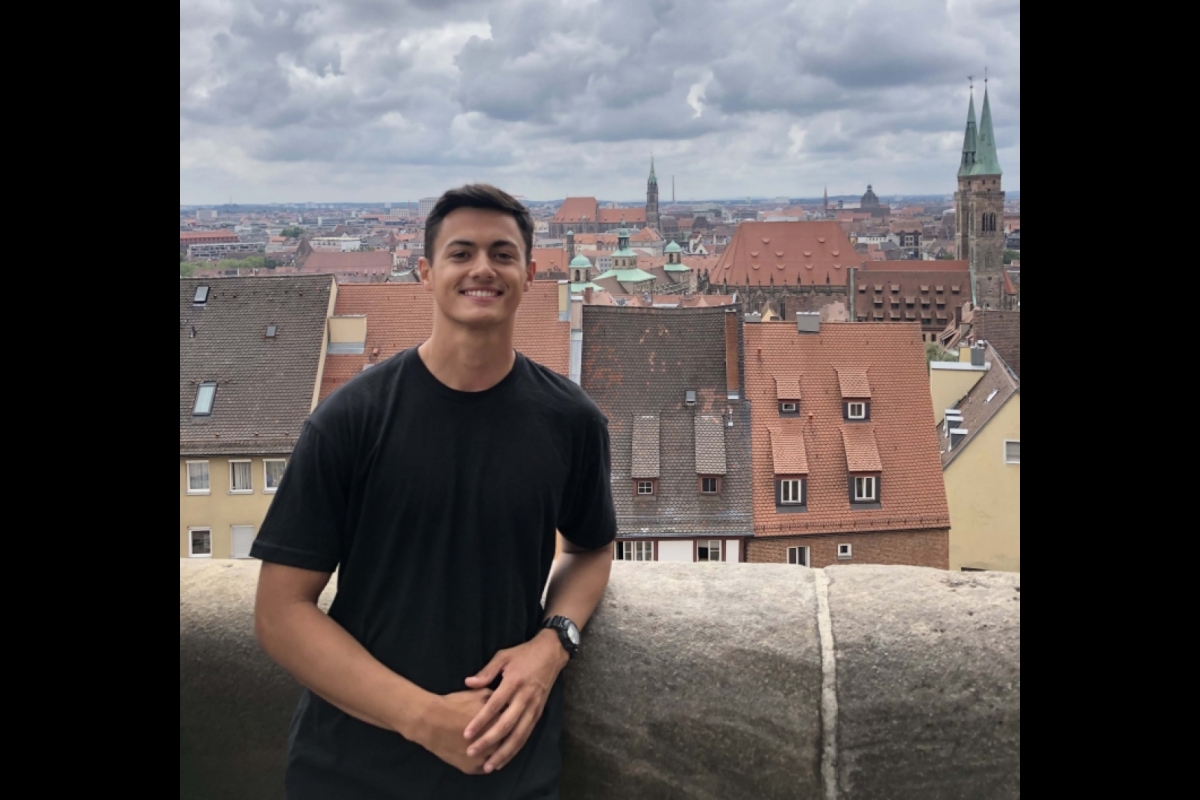 ASU Army ROTC Cadet Hayden Shedd stands in front of a backdrop of buildings in Germany.