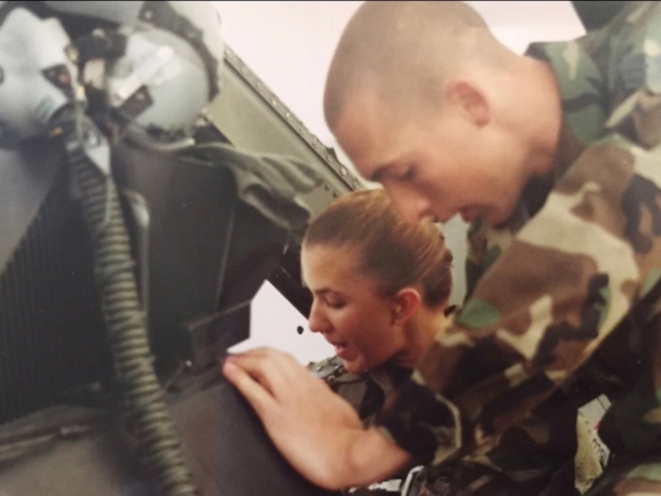 Air Force crew chief helps woman settle into the cockpit of an F-16D Fighting Falcon training fighter
