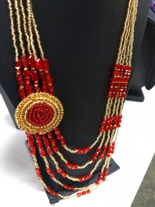 Red and gold beaded necklace from Nepal displayed at the refugee pop-up Global Market