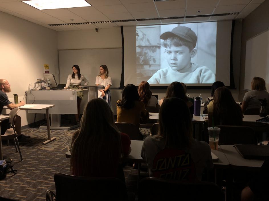 Picture of students presenting a video in the classroom.