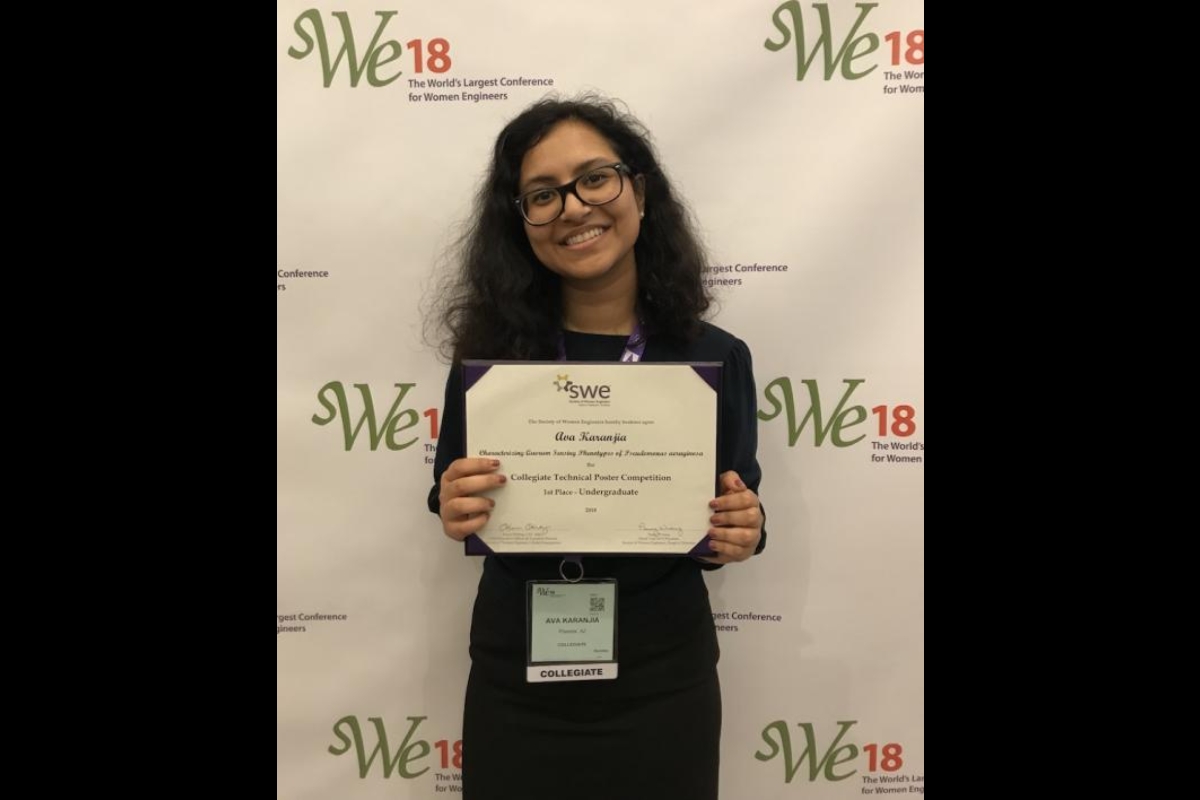 Ava Karanjia poses with her first-place award for the undergraduate collegiate technical poster competition at the Society of Women Engineers Conference.