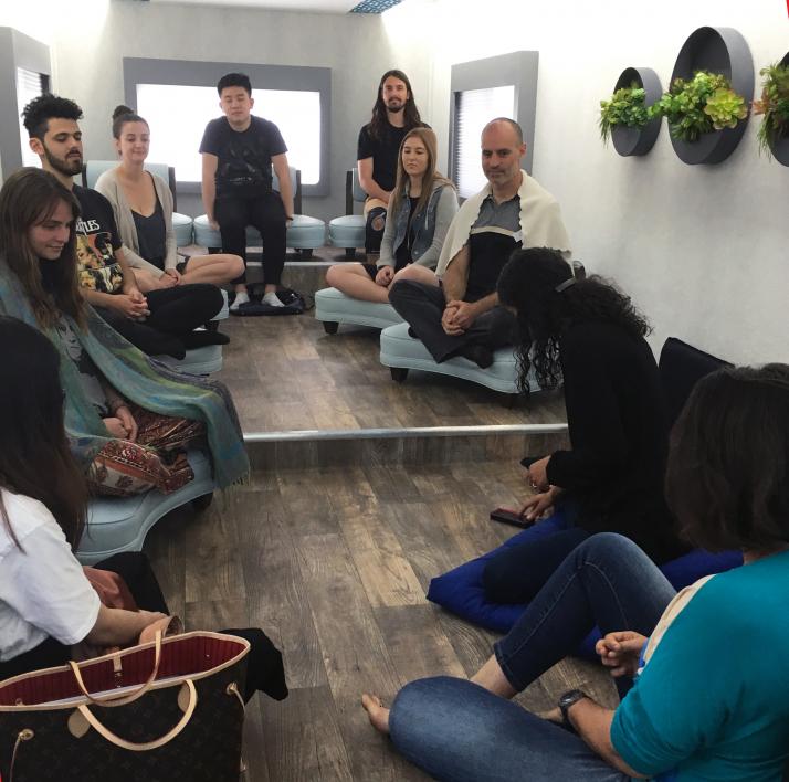 A group sits for a mindfulness session inside the M2 truck