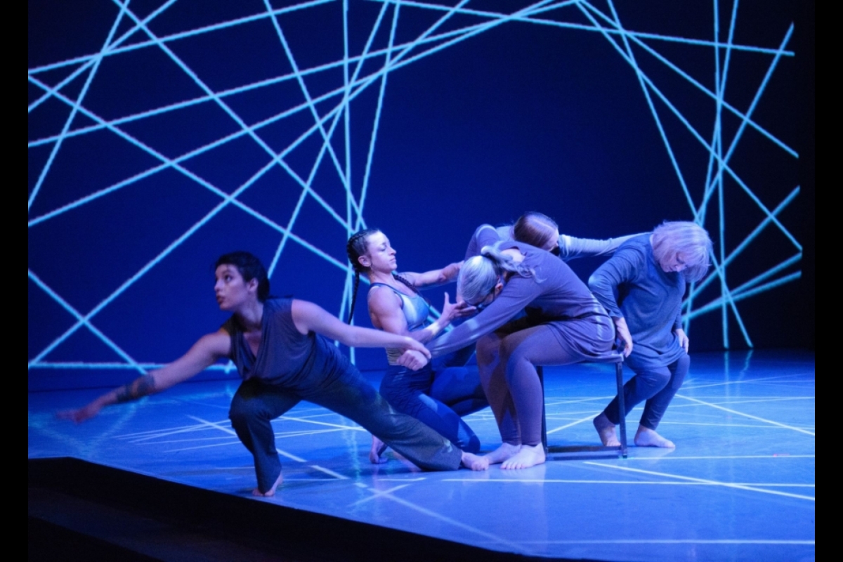 Dancers perform with geometric shapes in the background.
