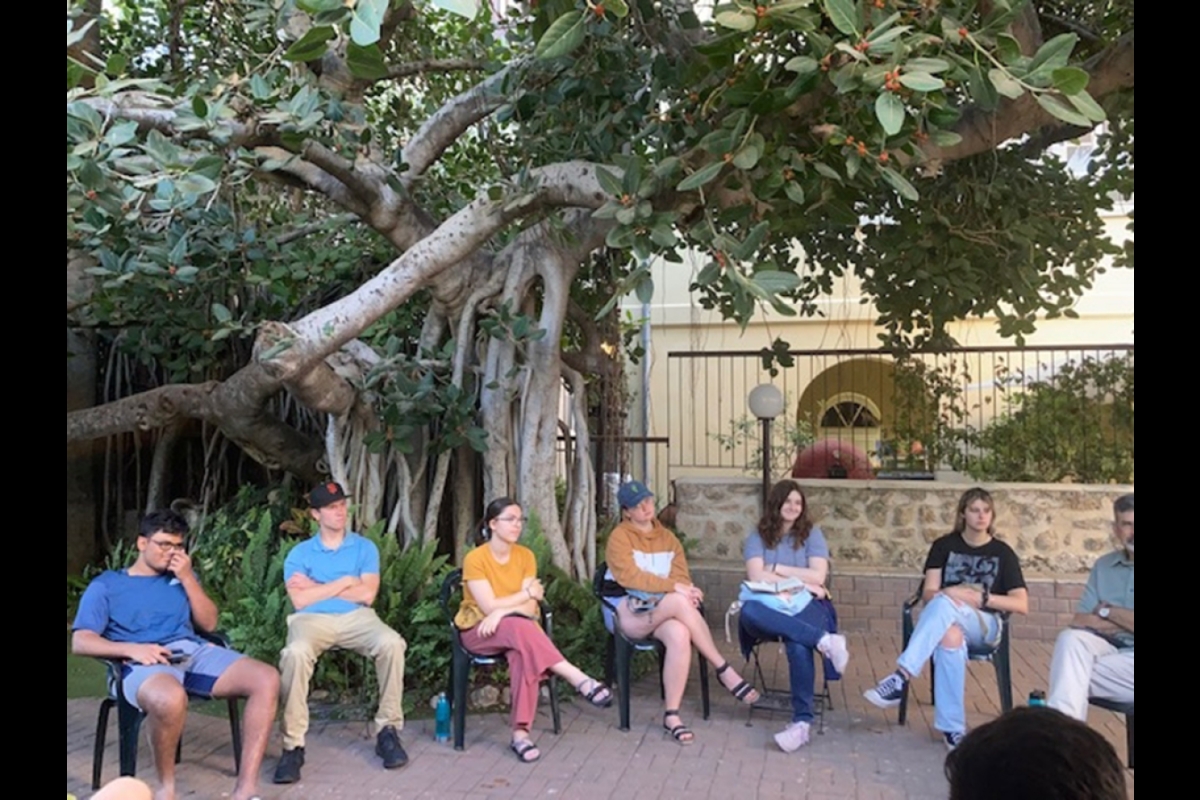 Students sit in a circle in a garden court in Isreal