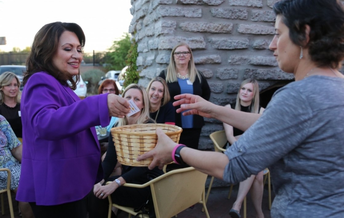 woman handing out papers from a basket